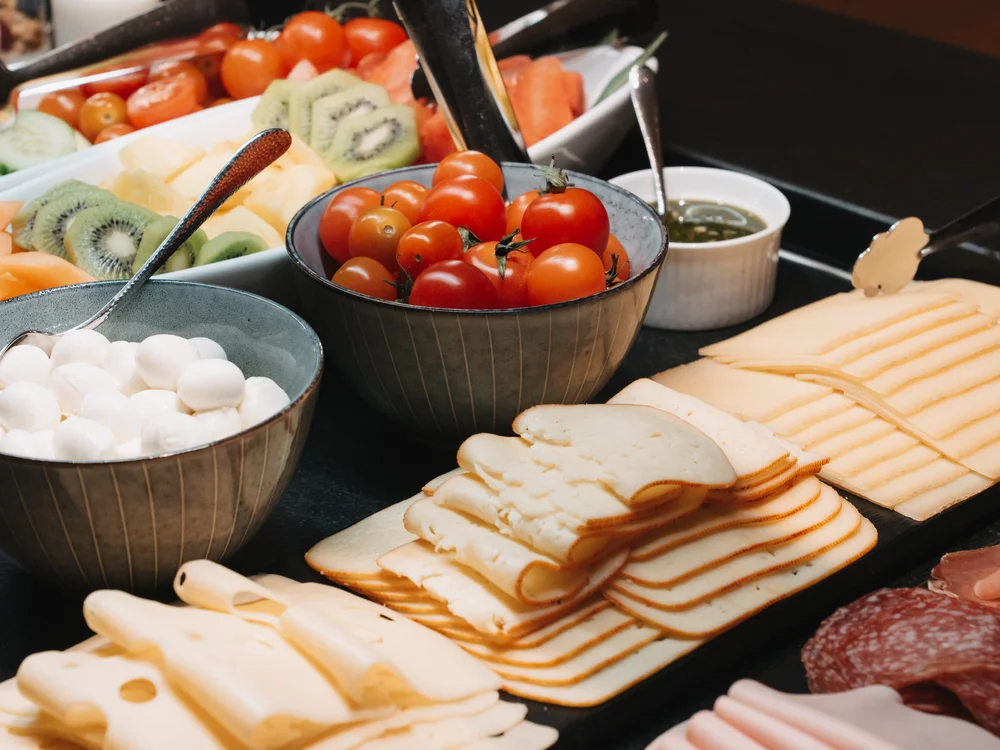 Ihre Auszeit in Lech am Arlberg Frühstücksbuffet mit Käse, Aufschnitt, Tomaten, Kiwis und weiteren Beilagen