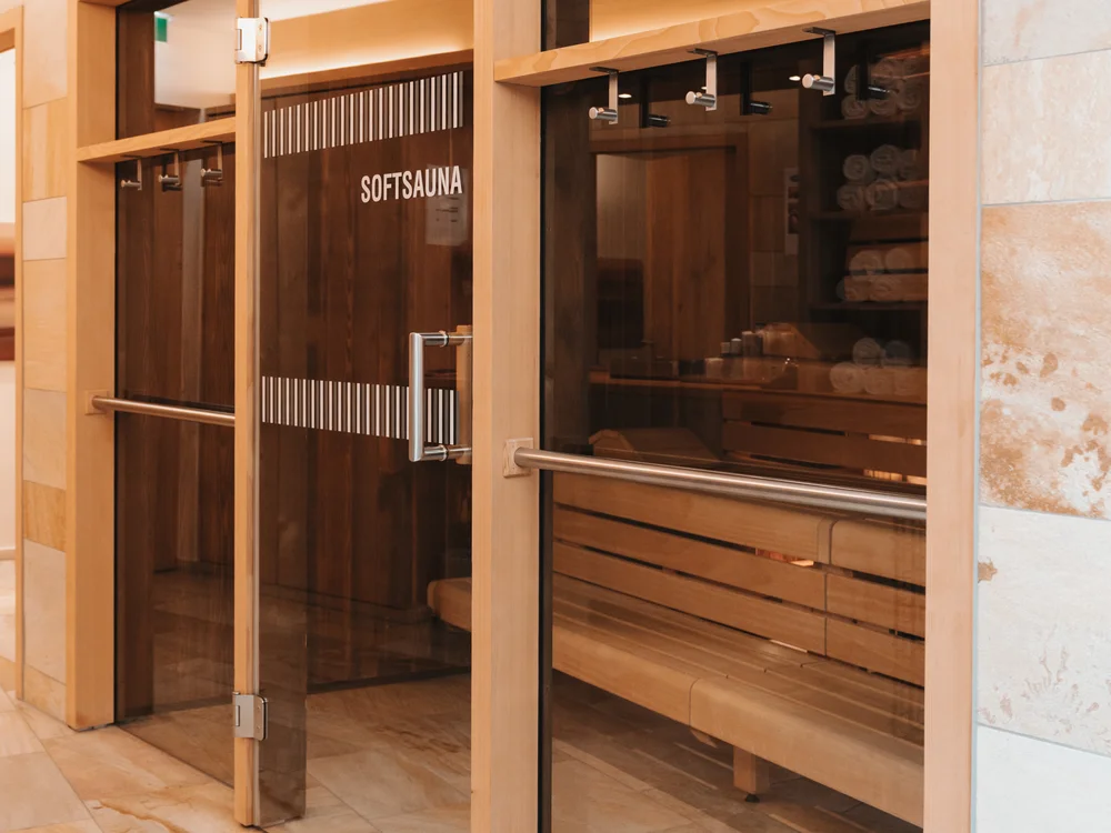 Ihre Auszeit in Lech am Arlberg Eingang einer Softsauna mit Glastüren und Holzbänken