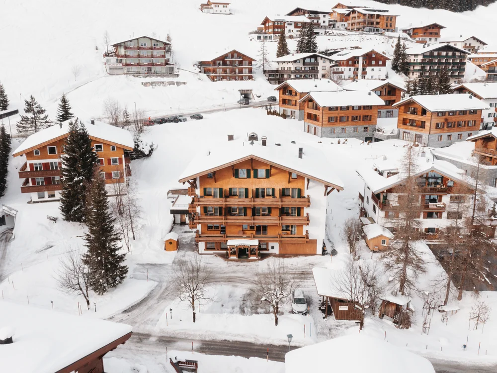 Ihre Auszeit in Lech am Arlberg Verschneites Bergdorf mit Holzhäusern und Ferienunterkünften