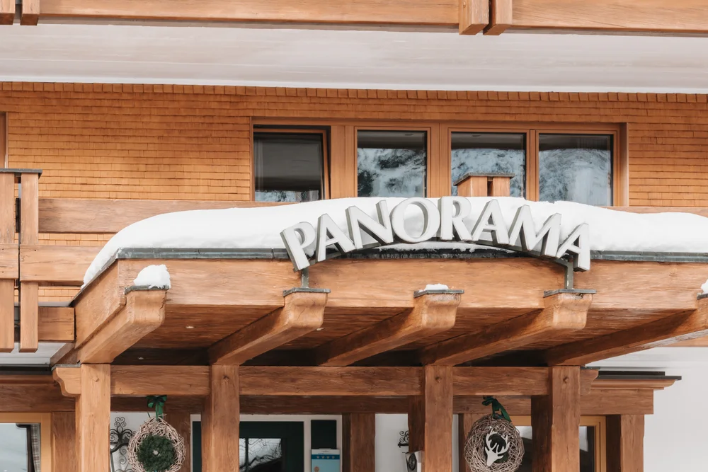 Eingang des Hotels Panorama mit Holzbalkon und winterlicher Dekoration