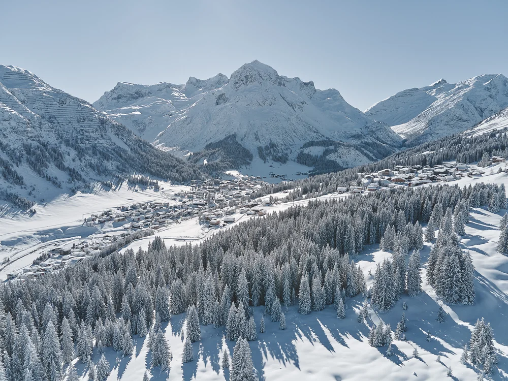Ihre Auszeit in Lech am Arlberg Verschneites Bergdorf zwischen schneebedeckten Tannen und hohen Alpengipfeln