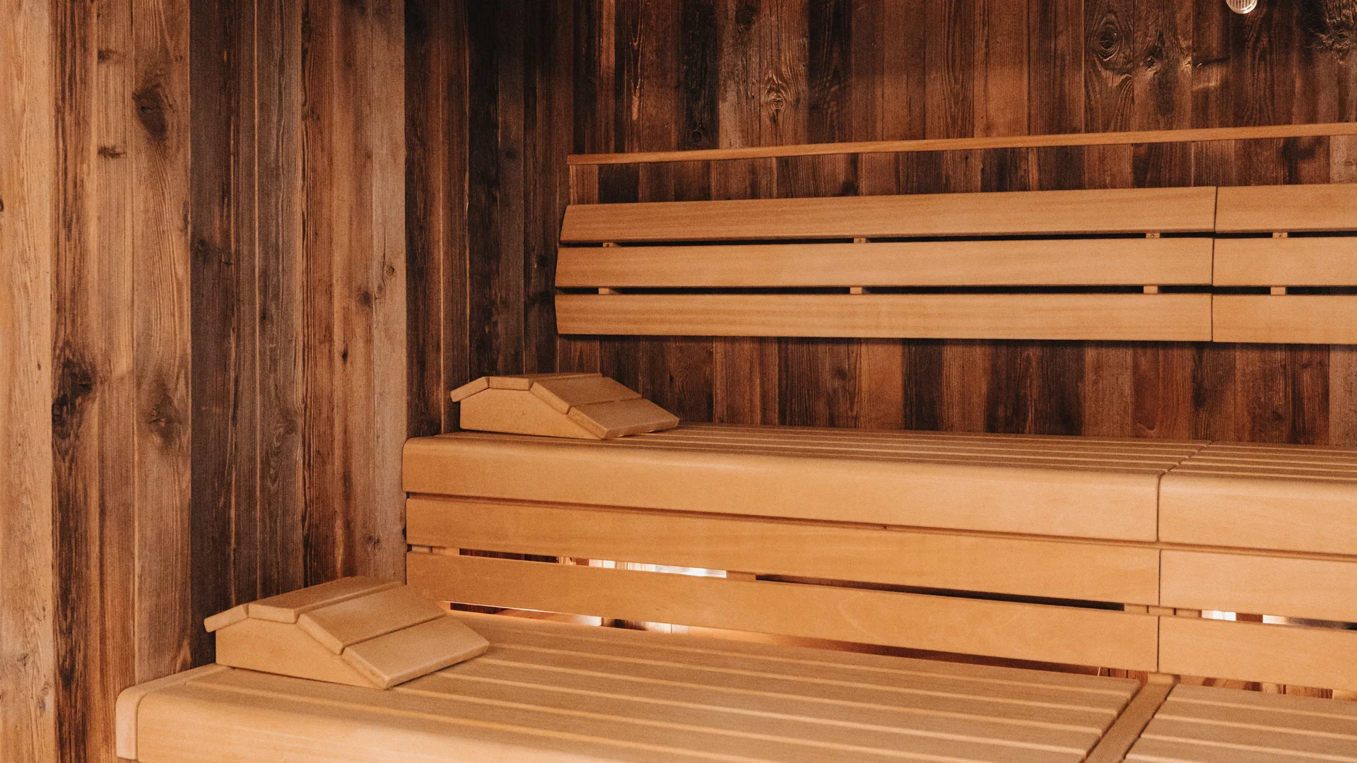 Holzsauna mit mehrstufigen Sitzbänken und Uhr an der Wand