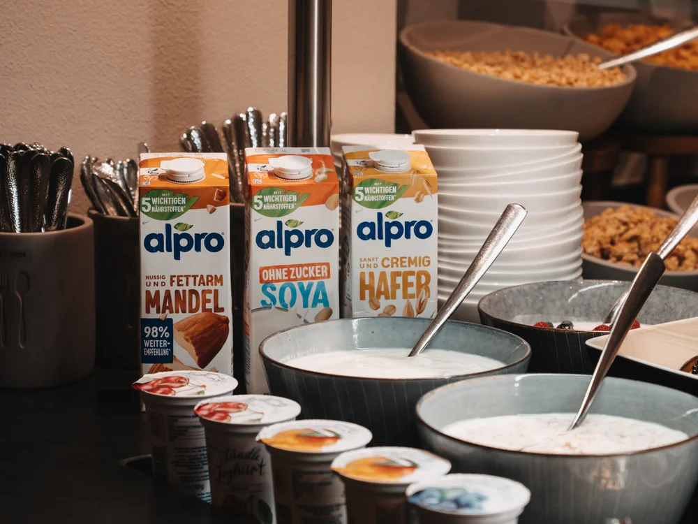 Ihre Auszeit in Lech am Arlberg Frühstücksbuffet mit pflanzlichen Drinks, Joghurt, Müslischalen und Besteck