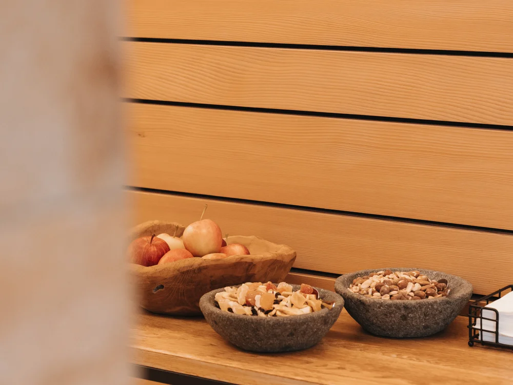 Ihre Auszeit in Lech am Arlberg Holztheke mit Obst und Schalen voller Nüsse und Trockenfrüchte